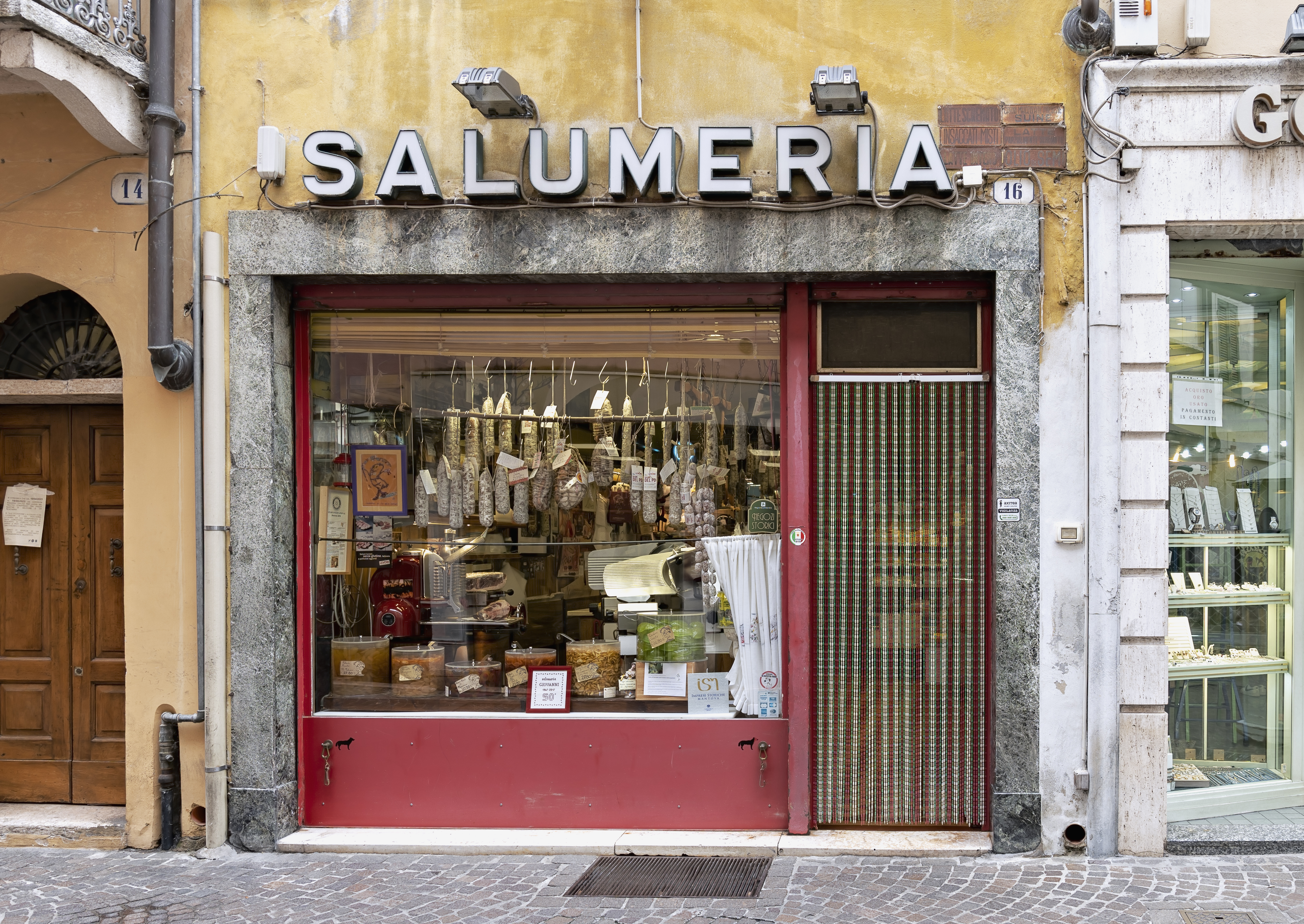 The shop window of an old-style salumeria (delicatessen) in central Mantua (Mantova), Italy