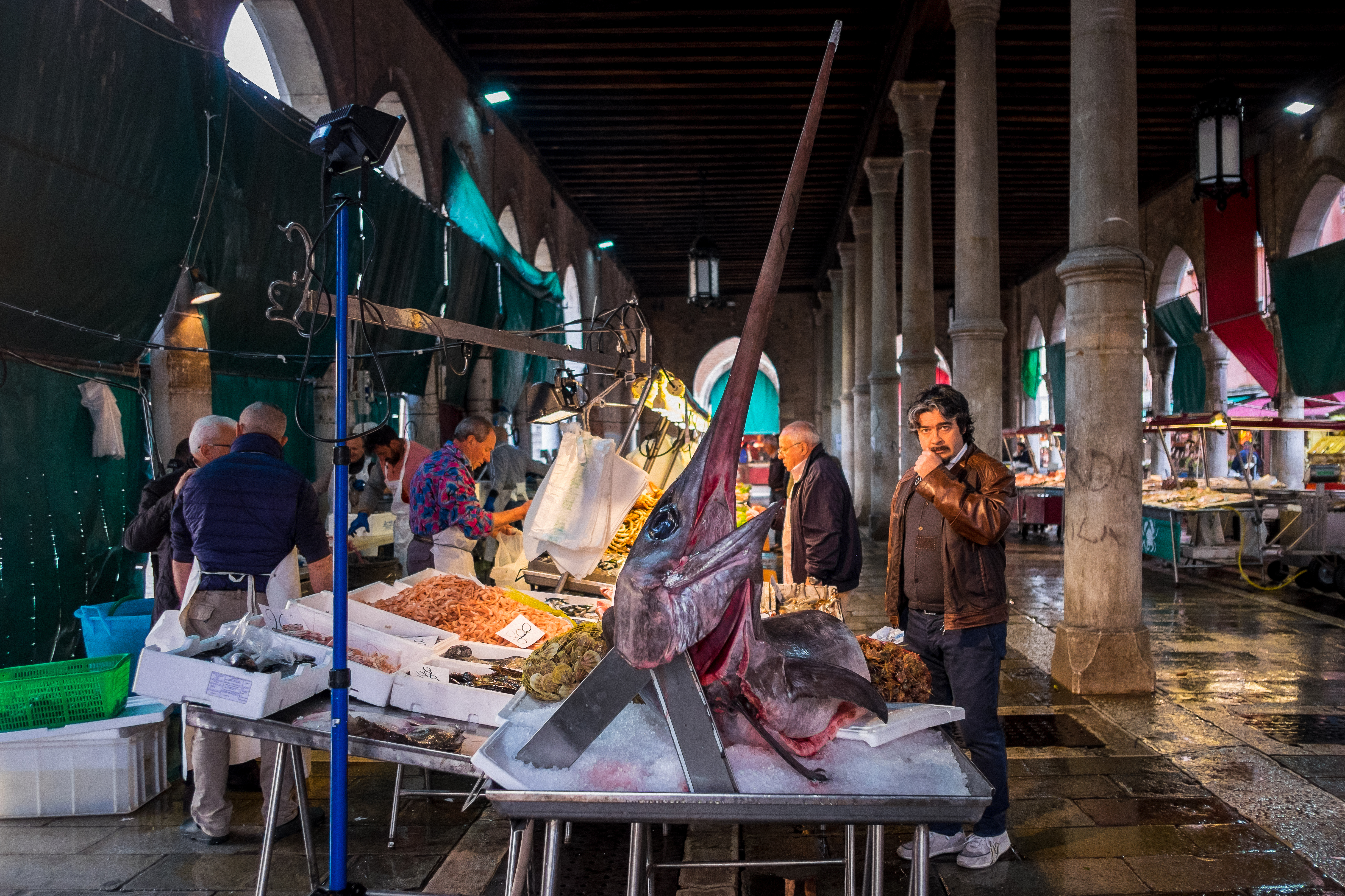 Fishmongers set up their stalls with a variety of fresh fish, including giant swordfish, at the Rialto fish market, Venice, Italy