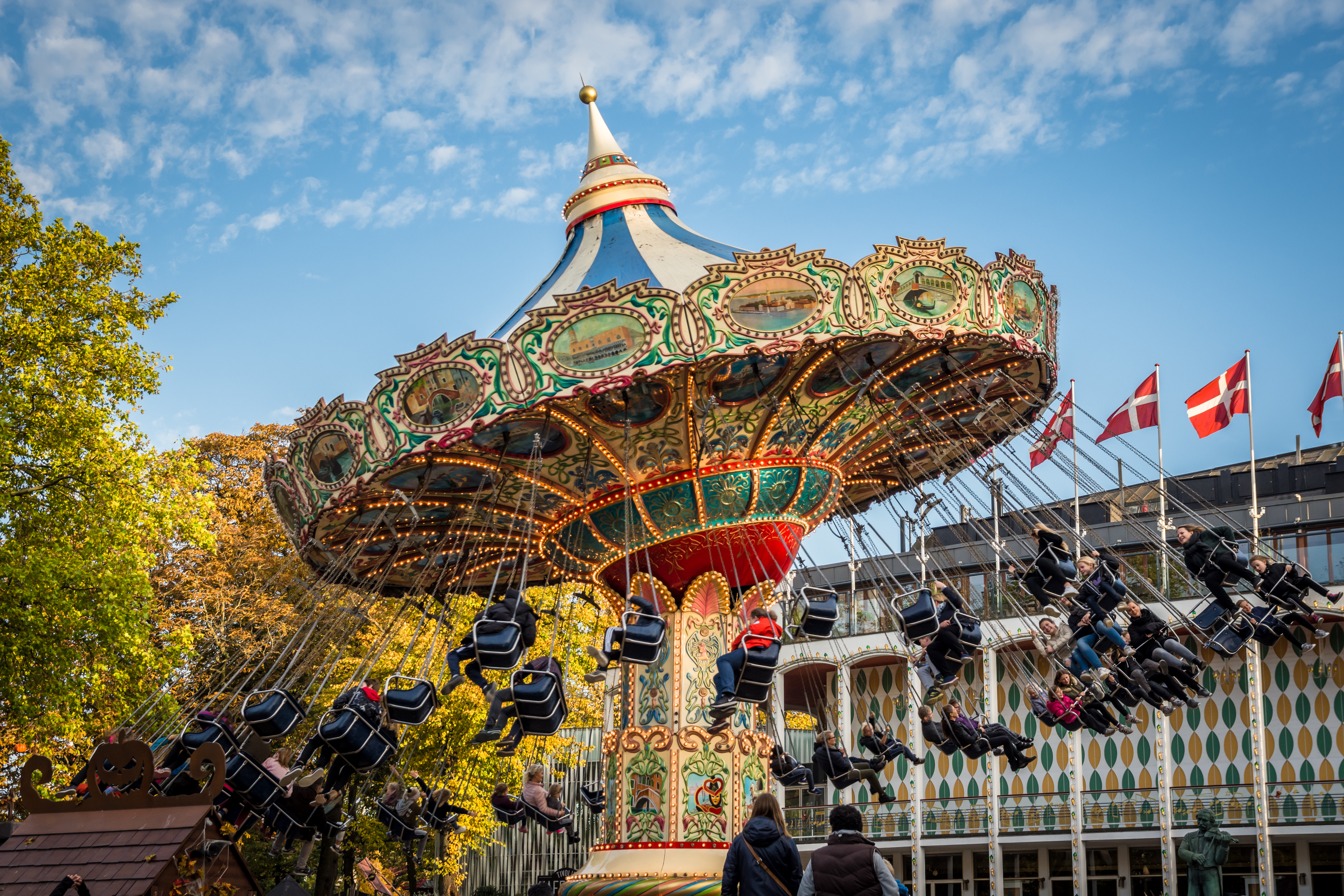 Families enjoying the old-fashioned swing ride at Tivoli Gardens, Copenhagen.